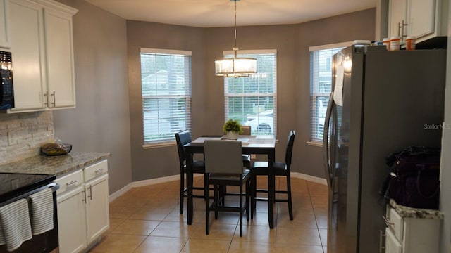 tiled dining space with a notable chandelier