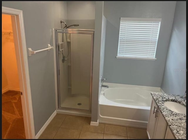 bathroom with tile patterned flooring, shower with separate bathtub, and vanity