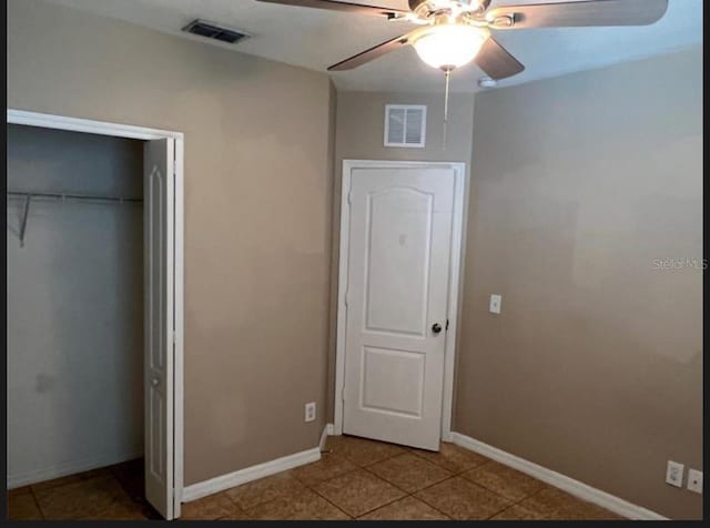 unfurnished bedroom featuring ceiling fan and a closet