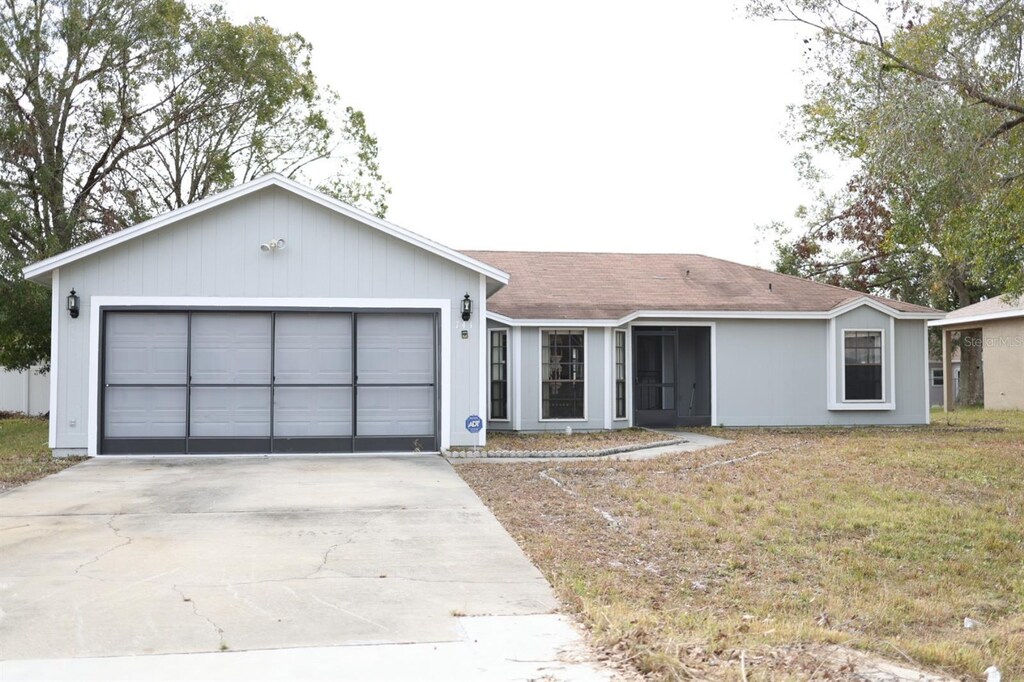 741 Caribou Dr, Kissimmee, FL 34759 - ranch-style house featuring a garage and a front yard