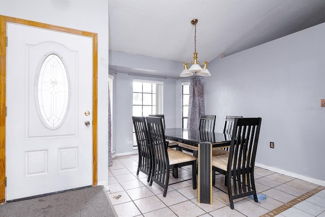 tiled dining space with vaulted ceiling, a chandelier, and a textured ceiling