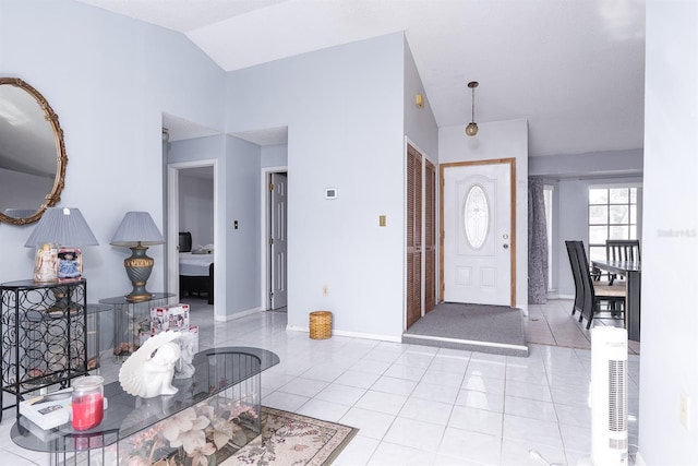 foyer entrance with light tile patterned floors and lofted ceiling