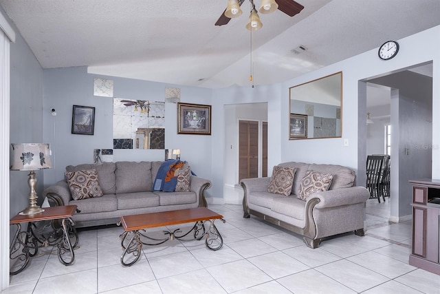 living room with lofted ceiling, light tile patterned floors, ceiling fan, and a textured ceiling