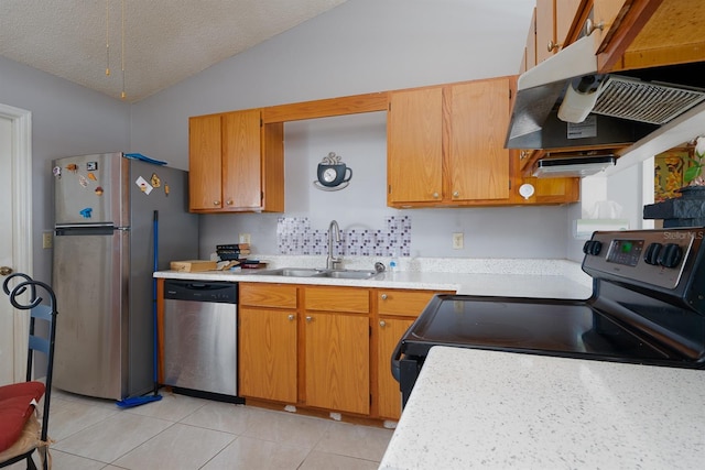 kitchen with a textured ceiling, appliances with stainless steel finishes, lofted ceiling, sink, and light tile patterned flooring