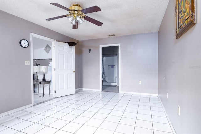 tiled empty room with a textured ceiling and ceiling fan