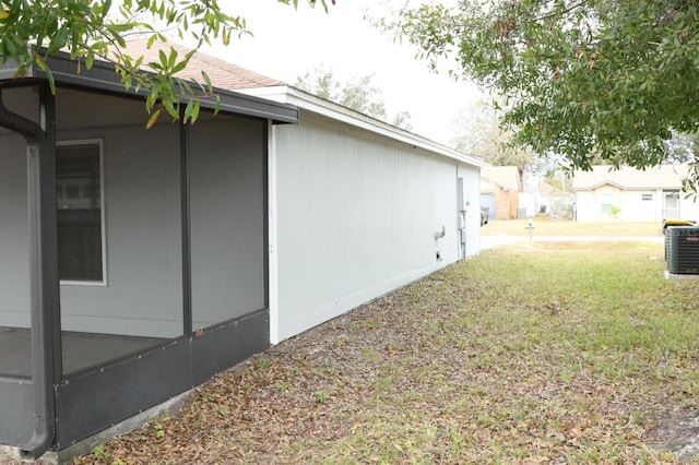 view of property exterior with cooling unit and a yard