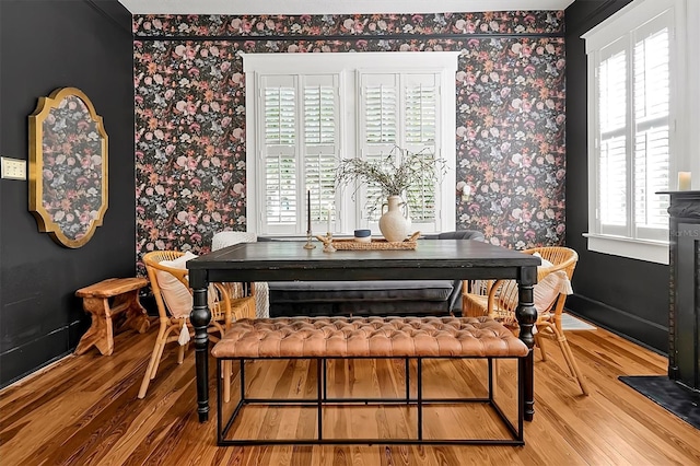 dining room featuring wallpapered walls and wood finished floors