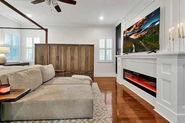 living area featuring a wealth of natural light, dark wood finished floors, and ornamental molding