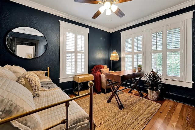 home office featuring a wealth of natural light, wood finished floors, a textured wall, and ornamental molding