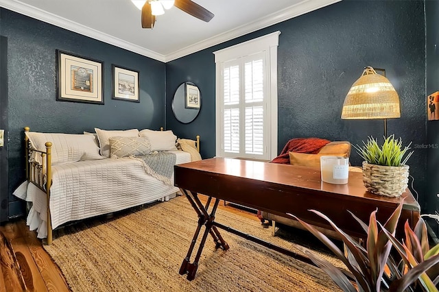 bedroom featuring a ceiling fan, wood finished floors, a textured wall, and ornamental molding