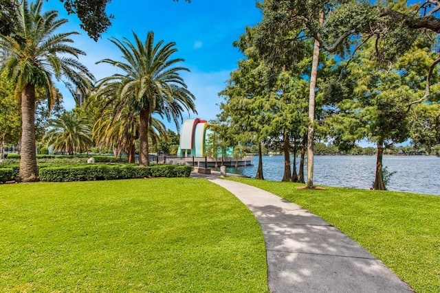 surrounding community featuring a water view and a lawn