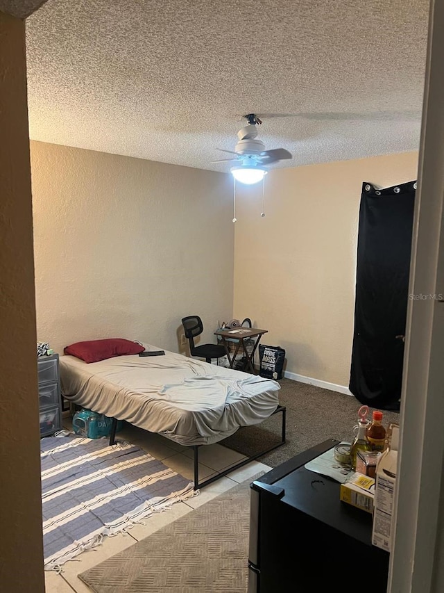 bedroom with ceiling fan and a textured ceiling