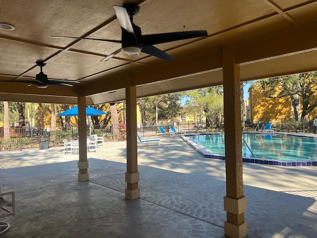 view of swimming pool featuring ceiling fan and a patio