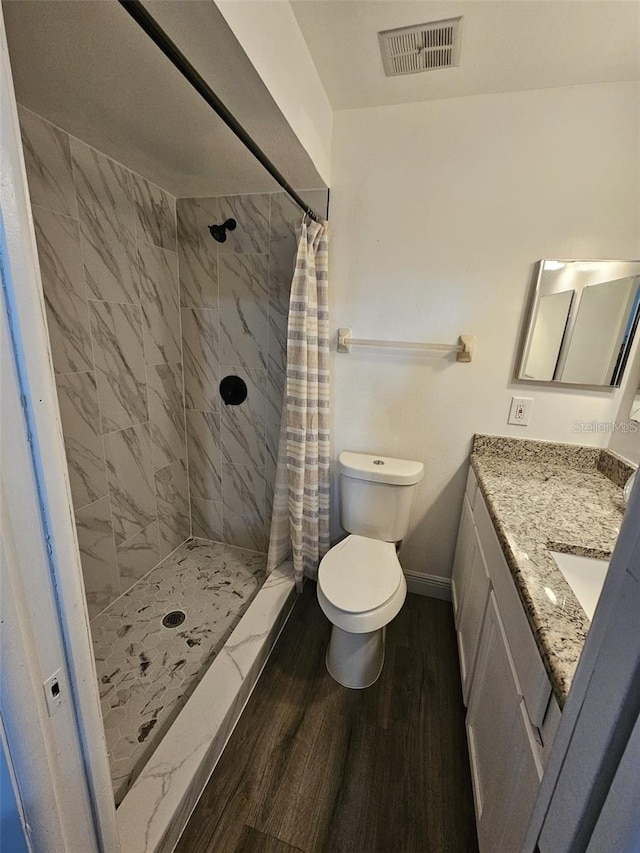 bathroom with hardwood / wood-style flooring, toilet, vanity, and a shower with shower curtain