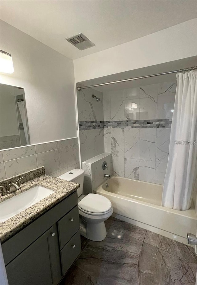 full bathroom featuring toilet, vanity, shower / tub combo with curtain, and tile walls