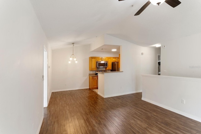 unfurnished living room with ceiling fan with notable chandelier, dark hardwood / wood-style flooring, and lofted ceiling