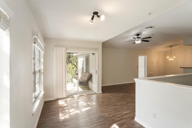 spare room featuring dark hardwood / wood-style flooring and ceiling fan with notable chandelier