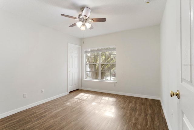 empty room with ceiling fan and dark hardwood / wood-style floors