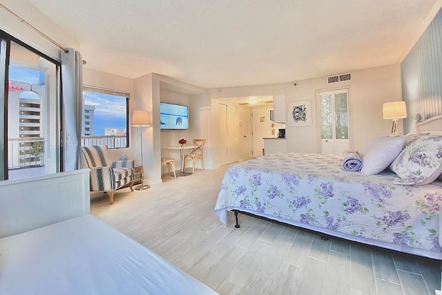 bedroom with wood-type flooring and a textured ceiling