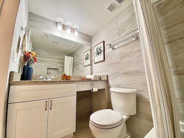 bathroom featuring vanity, a textured ceiling, tile walls, toilet, and curtained shower