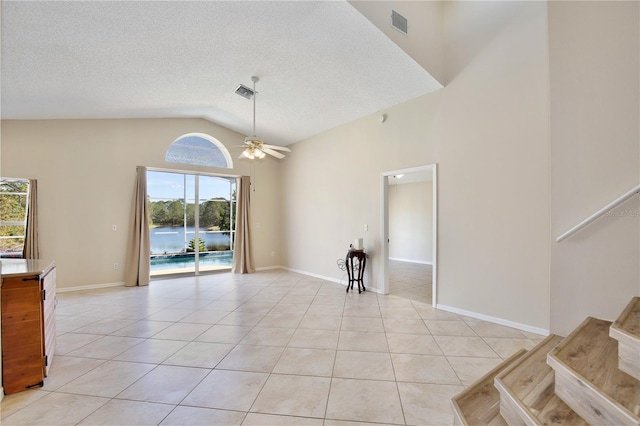 interior space with ceiling fan, high vaulted ceiling, a textured ceiling, and light tile patterned floors