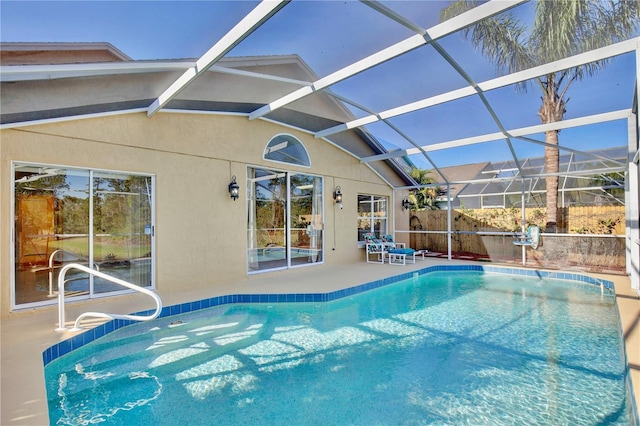 view of pool with glass enclosure and a patio area