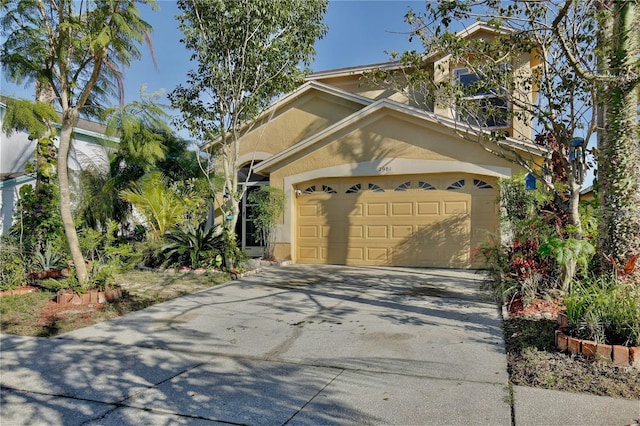 view of front of house with a garage, concrete driveway, and stucco siding