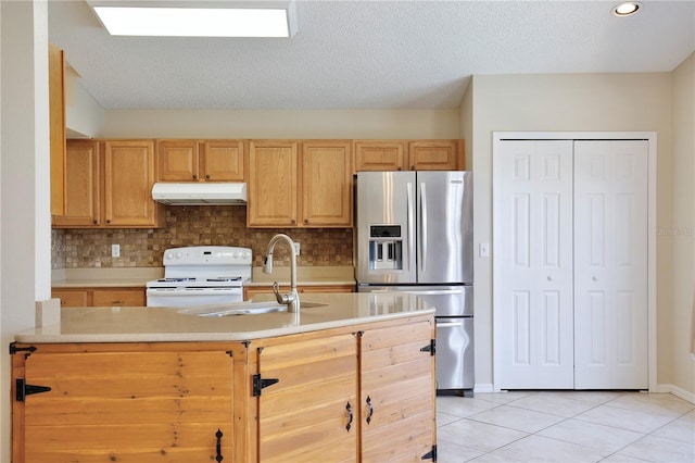 kitchen with light tile patterned floors, sink, stainless steel fridge, white range, and decorative backsplash