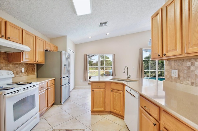 kitchen with lofted ceiling, sink, white appliances, backsplash, and kitchen peninsula