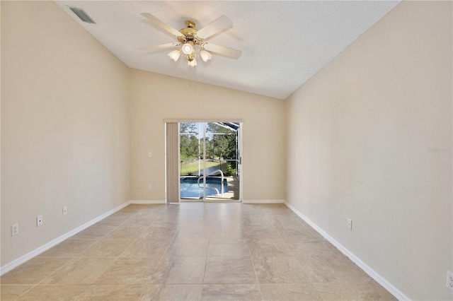 empty room with ceiling fan, vaulted ceiling, and a textured ceiling