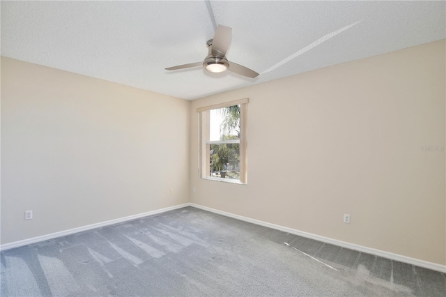 empty room with ceiling fan, a textured ceiling, and carpet flooring