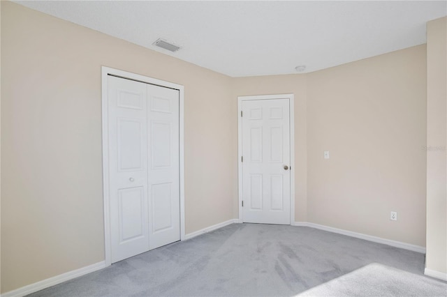 unfurnished bedroom featuring baseboards, a closet, visible vents, and carpet flooring