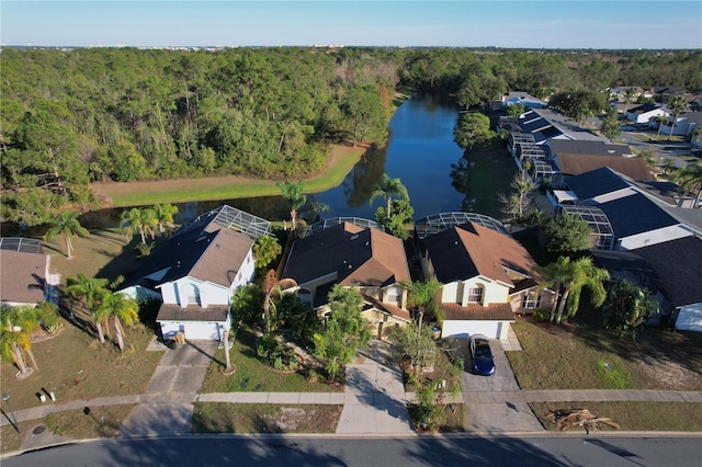 aerial view featuring a forest view, a water view, and a residential view