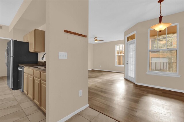 kitchen featuring ceiling fan, dishwasher, sink, and light brown cabinetry