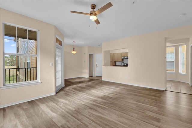 unfurnished living room featuring hardwood / wood-style flooring and ceiling fan