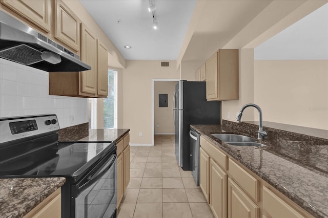 kitchen with sink, dark stone counters, range hood, and appliances with stainless steel finishes