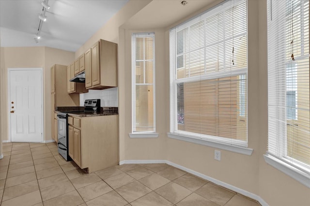 kitchen with light tile patterned flooring, electric stove, light brown cabinetry, and dark stone counters