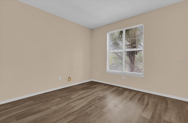 unfurnished room with a healthy amount of sunlight and hardwood / wood-style flooring