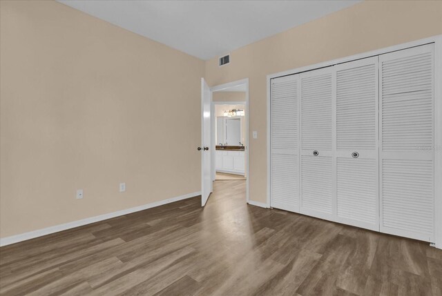 unfurnished bedroom featuring a closet and hardwood / wood-style floors