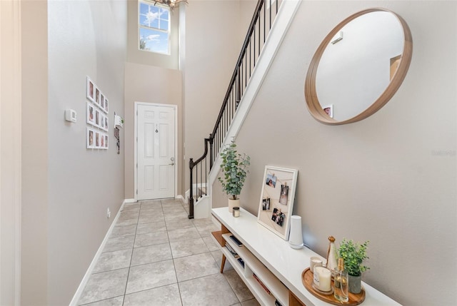 entrance foyer featuring a towering ceiling and light tile patterned floors