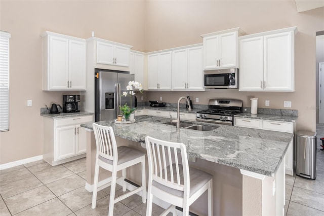 kitchen with a kitchen breakfast bar, light tile patterned floors, and stainless steel appliances