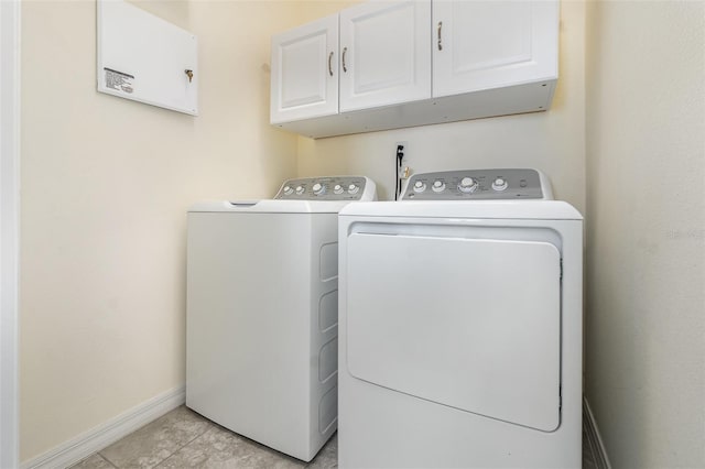 laundry area featuring cabinets, light tile patterned floors, and separate washer and dryer