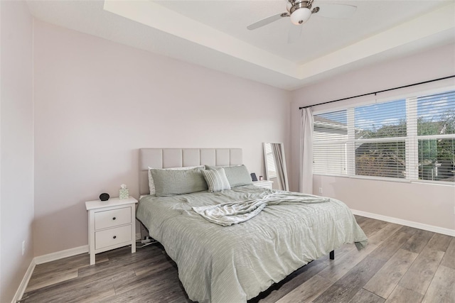 bedroom with a tray ceiling, ceiling fan, and hardwood / wood-style floors