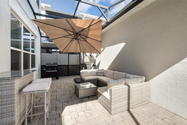 view of patio with an outdoor living space, glass enclosure, and grilling area