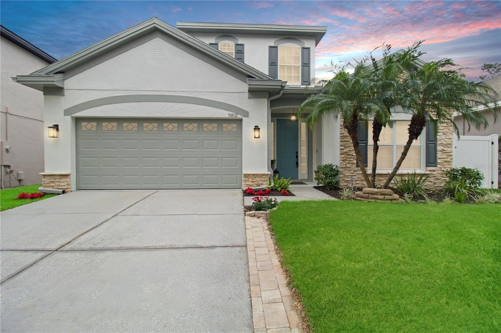 view of front of property with a garage and a lawn