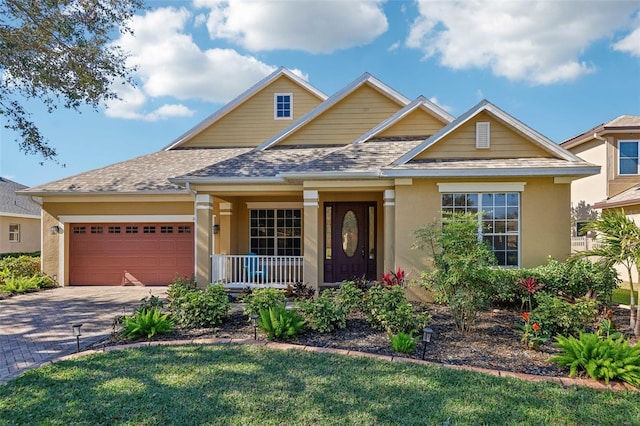 craftsman inspired home with a front yard, a porch, and a garage