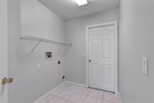 washroom featuring hookup for a washing machine, electric dryer hookup, light tile patterned floors, and a textured ceiling