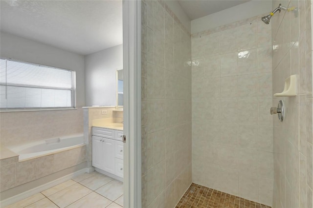 bathroom featuring tile patterned flooring, vanity, and shower with separate bathtub