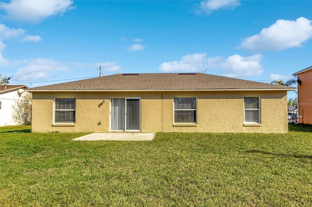 rear view of house featuring a yard and a patio