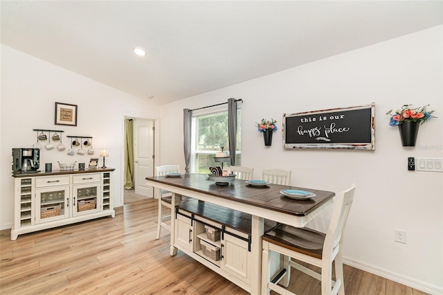 dining room featuring lofted ceiling and light wood-type flooring